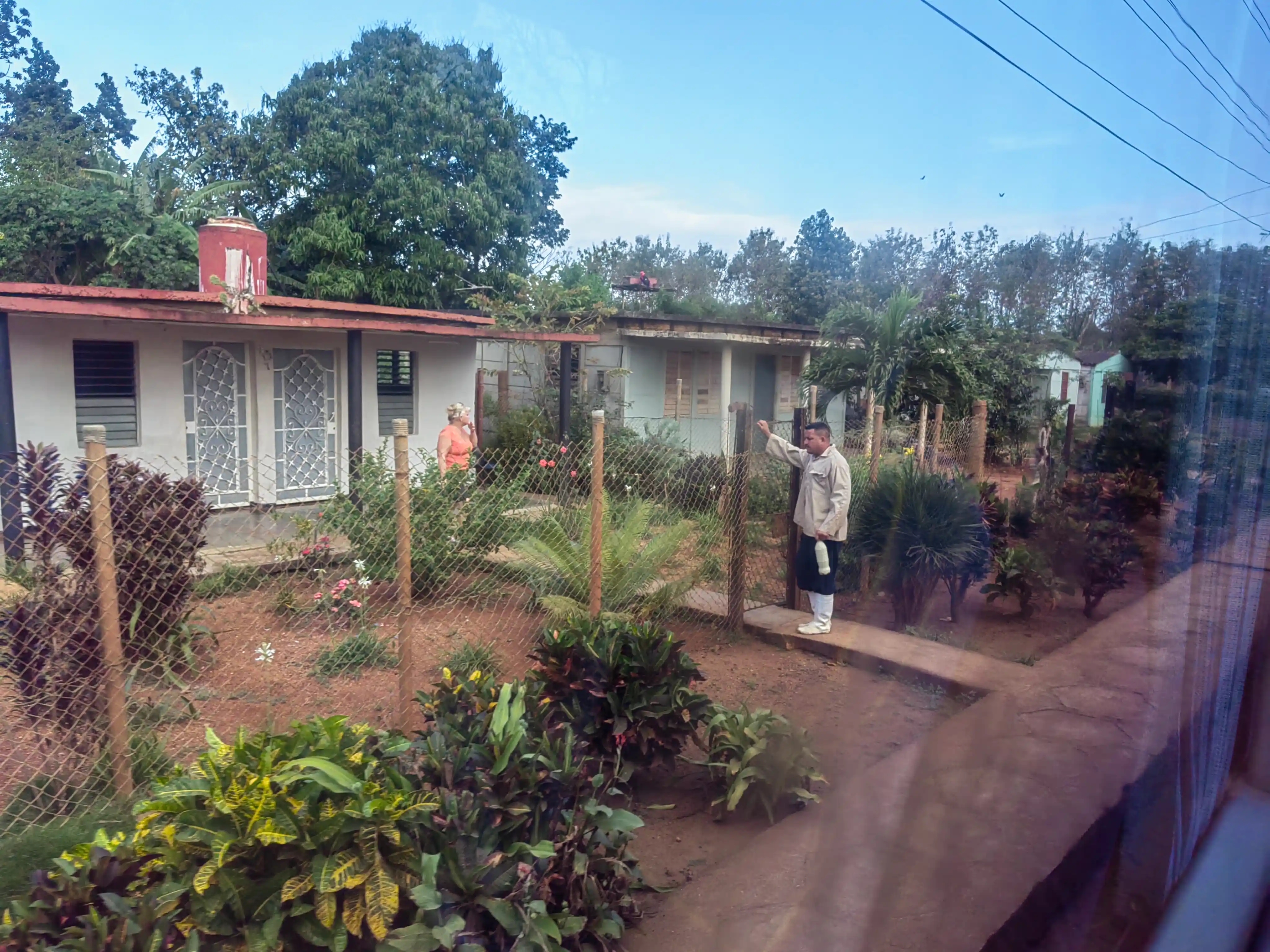 Man waving in rural yard
